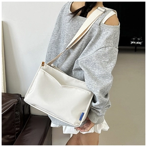 Detailed side view of white large capacity messenger bag with wide strap and outer pocket