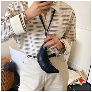Mini black croissant leather neck bag shown on model for size and style reference