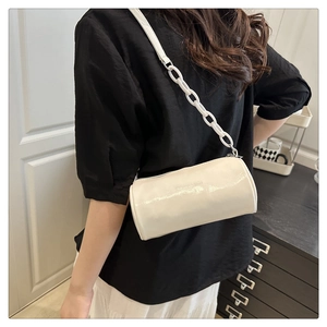 Detail of white glossy barrel bag with bold chunky chain strap and fashion lettering