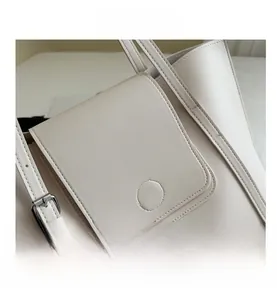 Close-up of off-white leather tote bag with silver buckle and fine stitching details