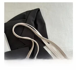 Detailed side view of beige quilted tote bag with slim handles and matte leather texture