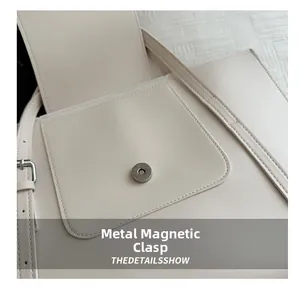 Macro detail of silver magnetic clasp on premium cream leather tote bag for women