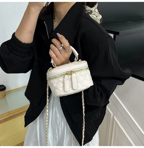 Detailansicht der beigen gesteppten Mini-Tasche mit Goldkette und Tragegriff oben