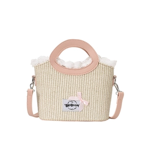Summer straw bucket bag with pink leather handles and lace trim in beige