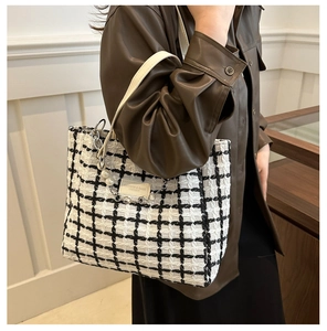 Detail of tweed checkered tote with pearl chain charm and leather shoulder strap