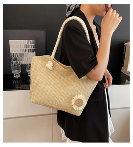 Dettaglio della borsa tote in paglia intrecciata con margherita e manico in cotone