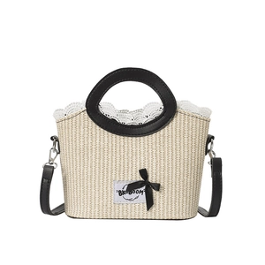 Beige straw woven handbag with black ring handle and lace bow detail for summer style