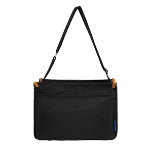 Minimalist black messenger bag with adjustable strap and orange leather accents