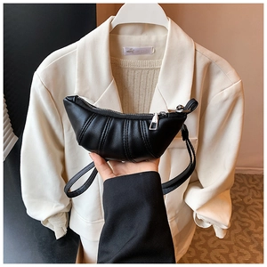 Detail showing black pleated croissant bag with smooth zipper closure and soft PU leather