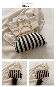 Detail of black and white striped handbag with gold metal frame and spherical clasp