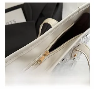 Detail des goldenen Reißverschlusses und dunklen Futters der weißen Punkte-Tasche