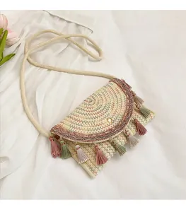Close-up of woven crossbody saddle bag with colorful wave embroidery and tassels
