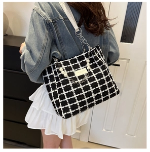Detail of checkered tweed tote bag featuring luxury pearl and metal chain shoulder strap