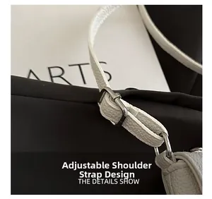 Detail of adjustable white lychee leather shoulder strap with silver buckle hardware