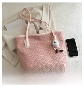 Sac cabas en cuir tressé rose avec un charmant monstre en peluche blanc et petit logo