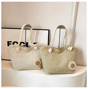 Dettaglio di borse tote in paglia con decorazioni a margherita e manici in corda