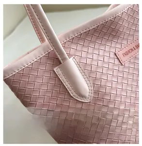 Gros plan du sac cabas rose tressé avec coutures précises et étiquette de mode rose