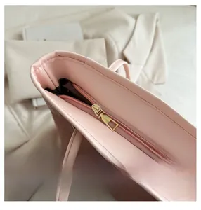 Détail de la fermeture éclair dorée et du cuir synthétique rose sur le sac cabas