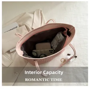 Vue de dessus d'un grand sac fourre-tout rose tressé avec ses rangements intérieurs spacieux
