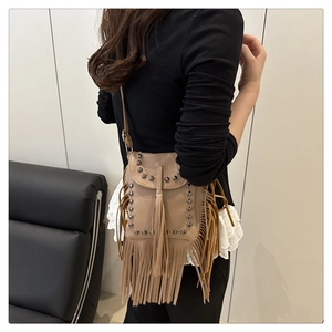 Detail of khaki pebbled leather crossbody bag featuring vintage studs and long tassels