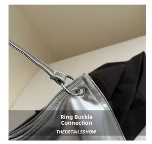 Detailed macro view of the silver metallic buckle and strap connection on the hobo bag