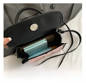 Detail view of the interior capacity of the black and pink crossbody bag with magnetic closure