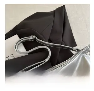 Detail of silver metallic leather handbag strap with adjustable buckle and eyelets