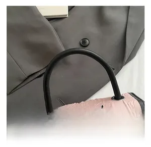 Detailed close-up of pink fabric handbag featuring black bow patterns and silver metal buckle