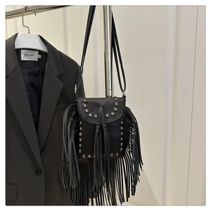 Close-up of black fringe crossbody bag with silver studs and lychee pattern leather texture
