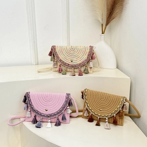 Three bohemian woven saddle bags with colorful tassels and embroidery on display stands