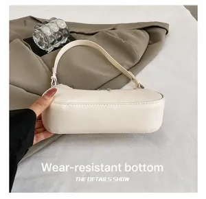 Detail shot of wear-resistant bottom and stitching on beige leather crescent bag