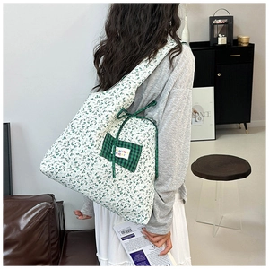 Detail of floral tote bag with blue flower pattern and green plaid bow pocket