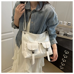 Detail of white glossy motorcycle bag featuring double front pockets and silver metal buckles