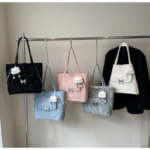 Detailed display of colorful pleated tote bags with butterfly charms and cloud pendants