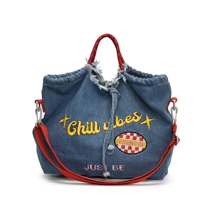 Blue denim tote bag with red handles featuring Chill vibes embroidery and raw edges