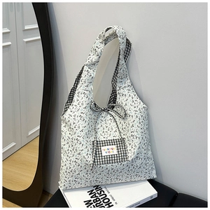 Detailed close-up of floral canvas tote bag featuring black checkered pocket and bow tie