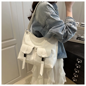 Detail of white glossy oversized hobo bag with vintage buckles worn on shoulder