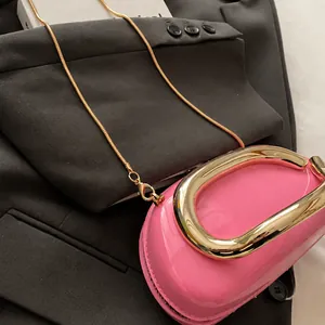 Detailed macro view of vibrant pink patent leather texture and sturdy gold metal U-handle