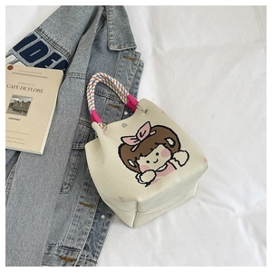 Detail of knitted mini bucket bag with cute cartoon girl print and rope handles