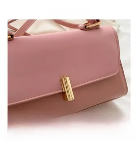 Détail d'un sac à main en cuir rose avec un fermoir cylindrique doré élégant