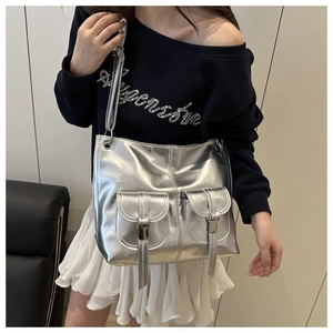 Metallic silver tote bag detail featuring symmetrical flap pockets and sleek PU finish