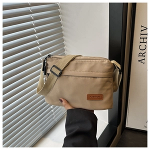 Détail du sac bandoulière en nylon kaki avec étiquette en cuir Fashion et sangle réglable