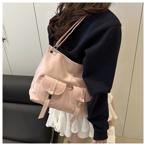 Detail of pink patent leather tote bag featuring dual front pockets and glossy texture
