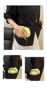 Detail of neon green mini oval clutch bag featuring a gold metal ring handle and chain
