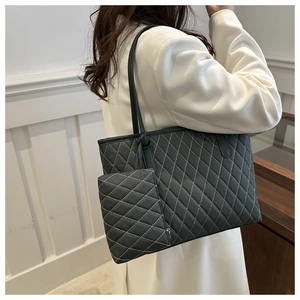 Détail d'un sac cabas gris matelassé avec une petite pochette zippée et fines lanières