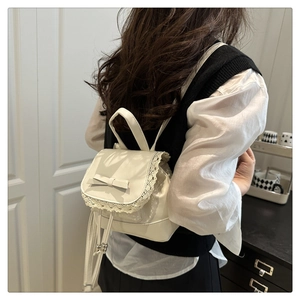 Sac à dos beige avec dentelle, détail de nœud et bretelles réglables porté par un modèle