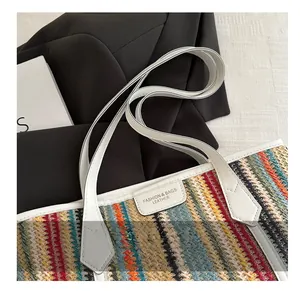 Détail de la texture tissée à chevrons et des poignées en similicuir sur un sac d'été