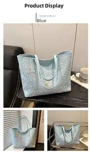 Detail of light blue quilted tote bag with colorful butterfly embroidery and metal studs