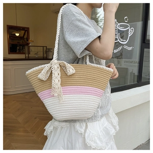 Détail du sac cabas bicolore avec grand nœud en dentelle et bandoulière tressée