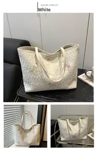 Macro view of floral relief and butterfly embroidery detail on white canvas tote bag